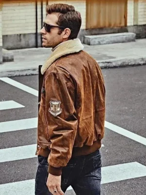 Vue de dos d'un homme en blouson bombardier cuir marron, traversant la rue, style pilote authentique.