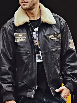 Homme portant un blouson en cuir foncé, style aviateur, avec un col en fourrure beige et des écussons militaires, veste homme.