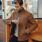 Homme portant une veste en cuir marron élégante, style décontracté et col montant, idéal pour toutes les saisons.
