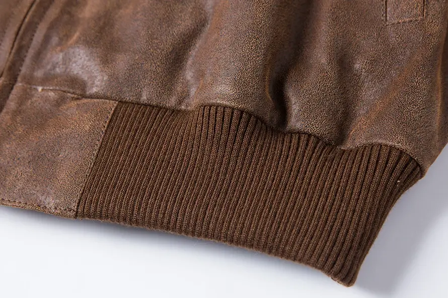 Bord-côte inférieur du blouson en daim marron, design classique, ajustement parfait.