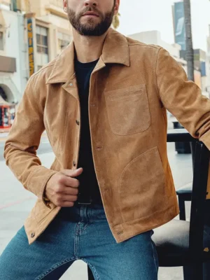 Homme assis portant un blouson en cuir homme en daim marron clair, style chic et décontracté en ville.