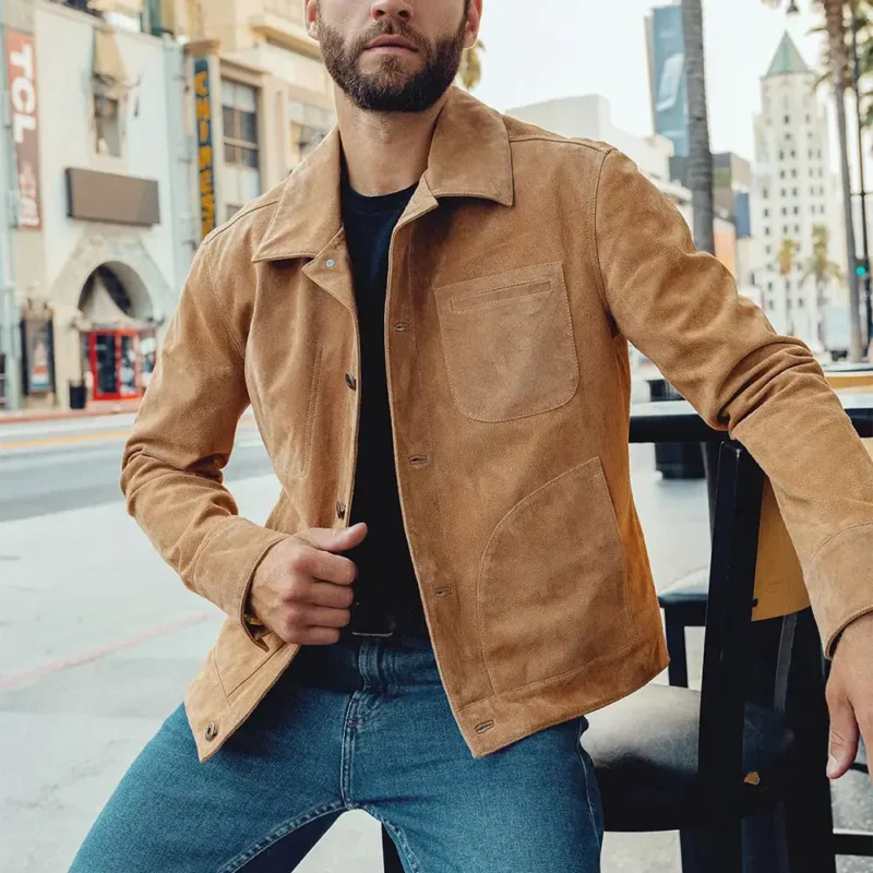 Homme assis portant un blouson en cuir homme en daim marron clair, style chic et décontracté en ville.