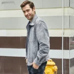 Homme souriant portant une veste en cuir gris, offrant un confort optimal et un style intemporel.