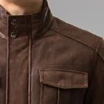 Gros plan sur les détails du blouson cuir homme marron: col, boutons pression et poches stylées.