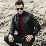 Blouson cuir pour homme, noir, modèle en position accroupie, reflétant une coupe confort et un style décontracté.