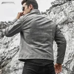 Vue de dos d'un homme portant un blouson en cuir gris résistant, mettant en avant la coupe et le style de la veste de moto classique.