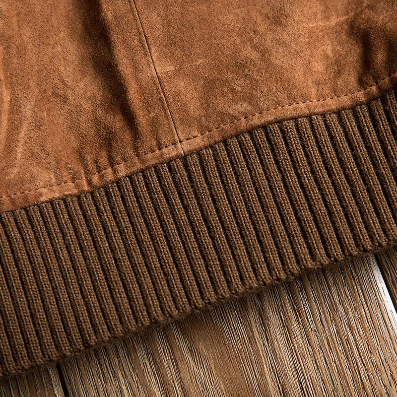 Détail du blouson homme en daim velours marron, avec son ourlet et ses poignets côtelés, finition soignée.