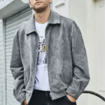 Blouson cuir homme chic aspect daim gris, porté par un homme élégant avec un t-shirt blanc et un jean sombre.