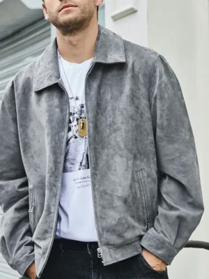 Blouson cuir homme chic aspect daim gris, porté par un homme élégant avec un t-shirt blanc et un jean sombre.