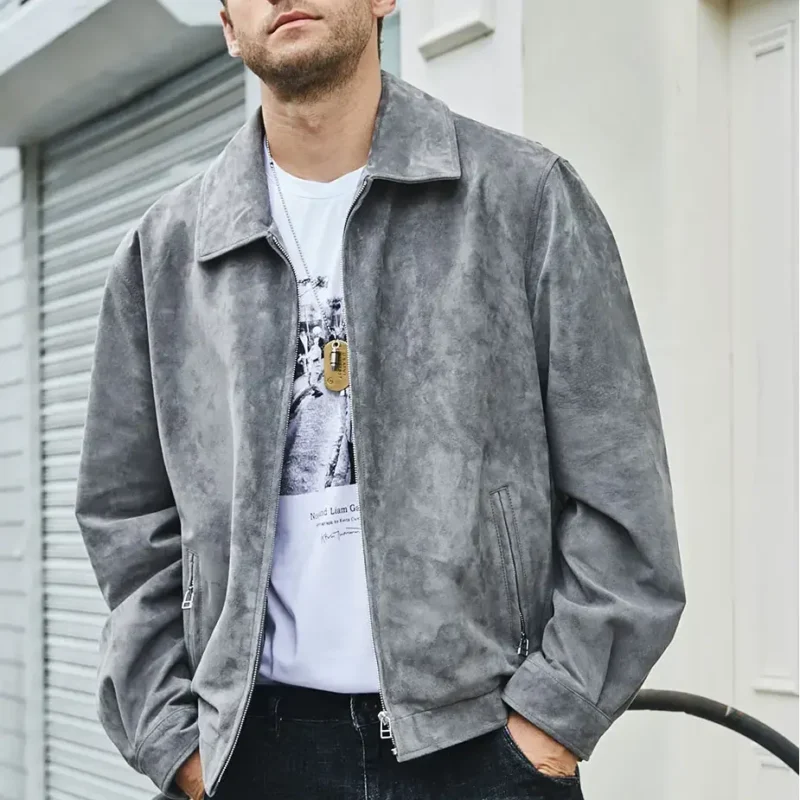 Blouson cuir homme chic aspect daim gris, porté par un homme élégant avec un t-shirt blanc et un jean sombre.