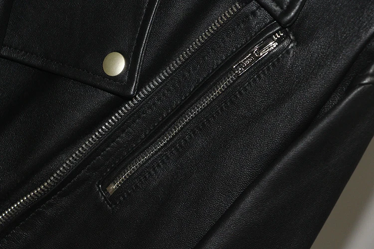 Fermeture éclair argentée et bouton-pression sur la poche de la veste en cuir pour femme.