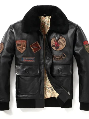Blouson aviateur en cuir noir avec écussons brodés et col en fourrure, vue de face.