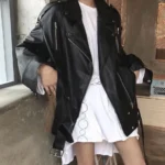 Blouson perfecto femme en cuir noir associé à une robe blanche, style contrasté et chic.