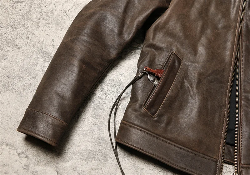 Manche et poche latérale de la veste en cuir, détail des coutures et qualité du cuir, blouson homme marron.
