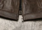 Fermeture éclair principale de la veste en cuir marron, détail de la glissière, qualité des finitions du blouson.